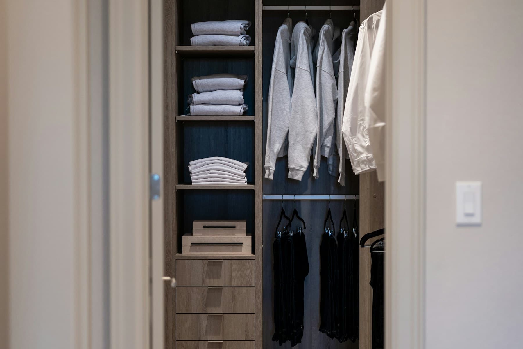 Dunkle Maßgarderobe mit Regalen und Schubladen